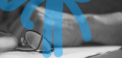 Close up shot of a person's glasses resting on top of documents on a tabletop. Image has a decorative graphic treatment on top of image.